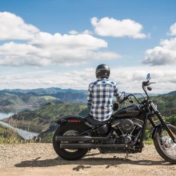 Man sitting on his motorcycle looking out at a beautiful view of nature.