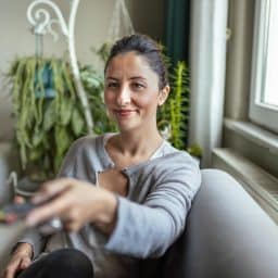 Young Adult Woman with Hearing Aid watching television