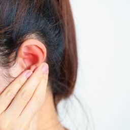 Woman holds hand behind one ear