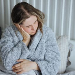 Woman holds ear in pain