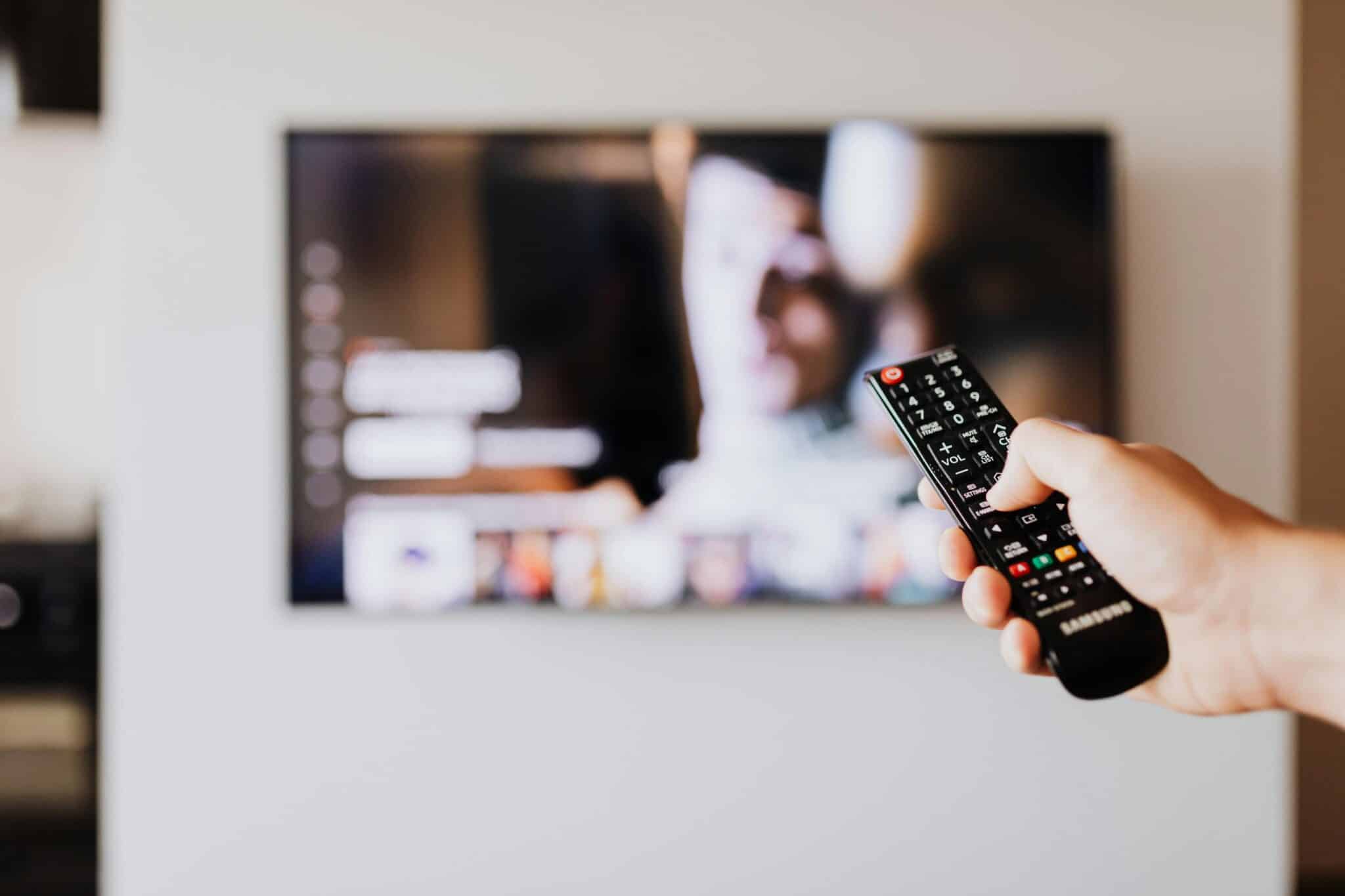 A remote held up in front of a television