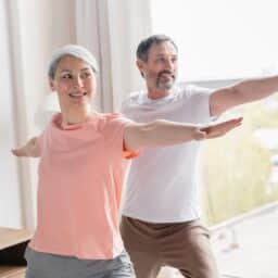 Couple doing balance exercises at home to reduce risk of falling