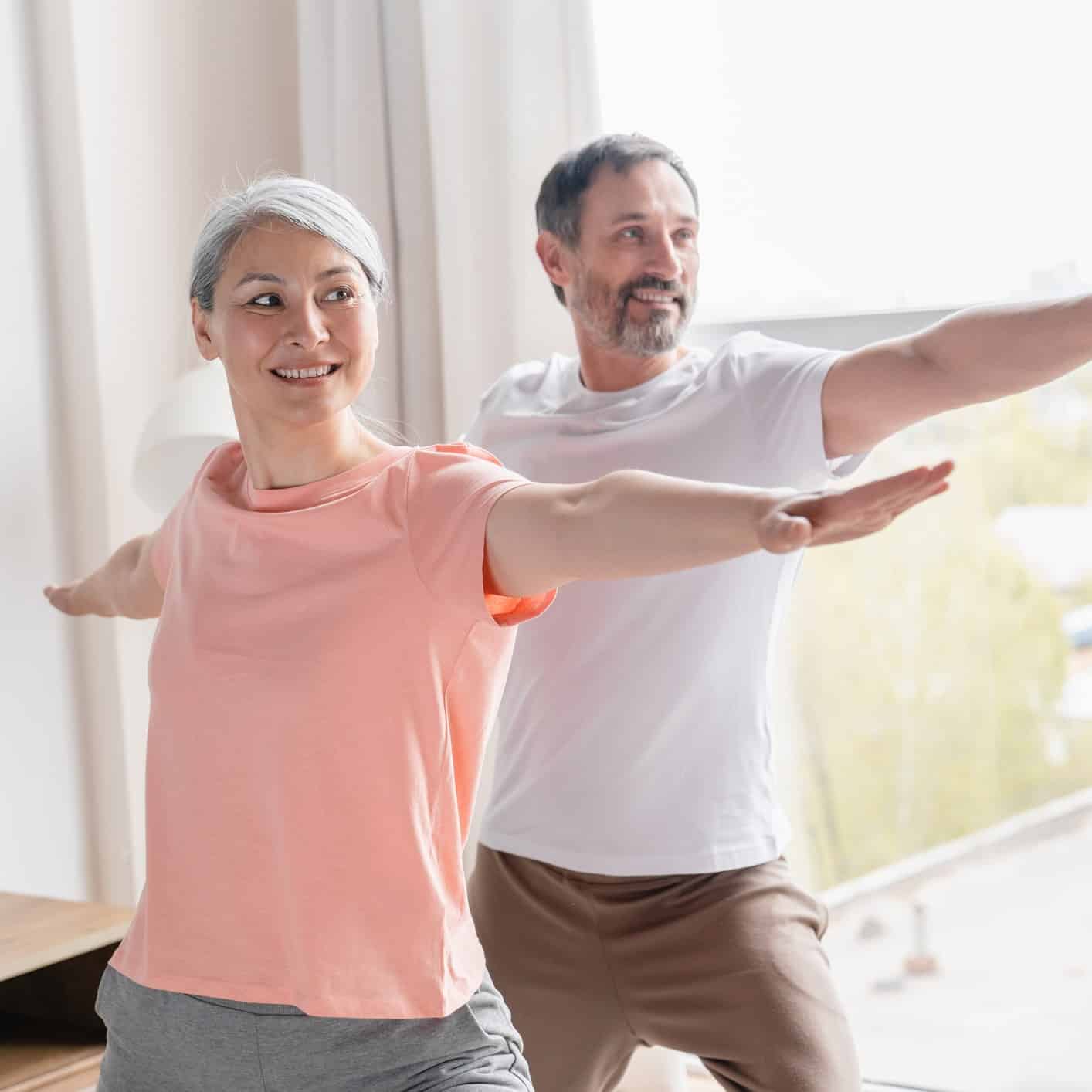 Couple doing balance exercises at home to reduce risk of falling