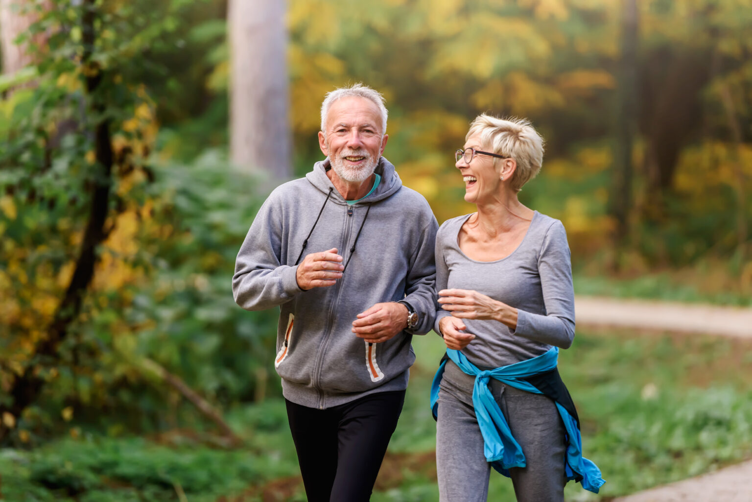 Active couple taking a walk in the forest during the fall.