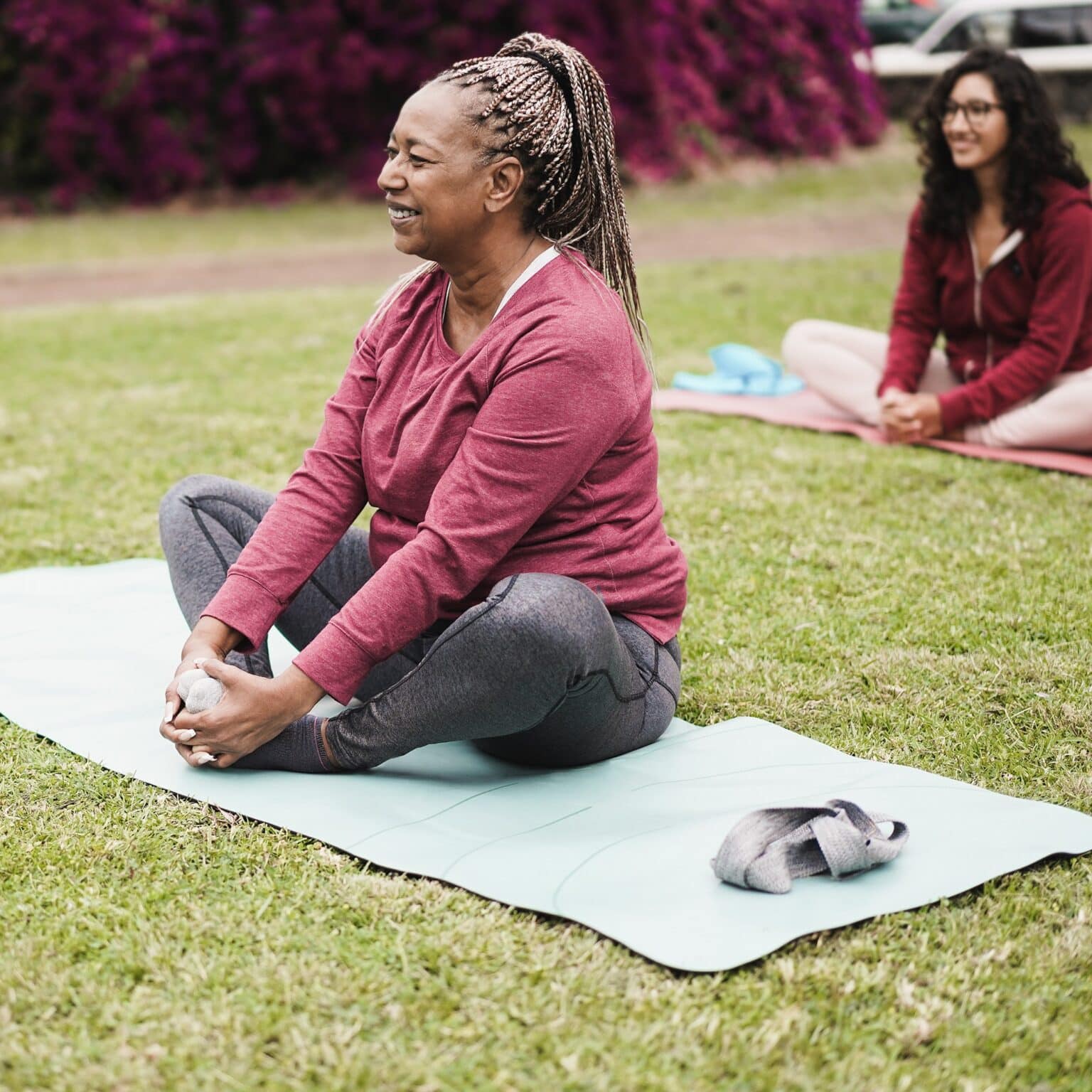 Smiling woman stretching during a group yoga class in the park