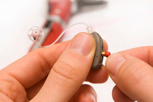 Picture of a hand holding a hearing aid